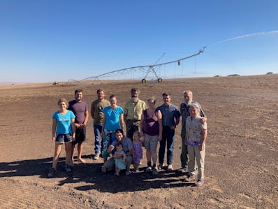 Nathan Stelzer, his parents, and family near irrigation pivot